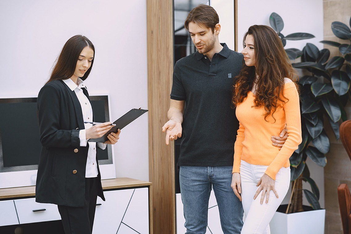 Couple in furniture store. Family choosing furniture in store while sales clerk consulting them.